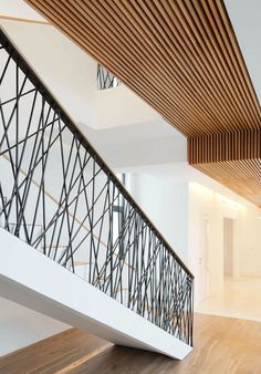 an empty room with wooden flooring and white walls on the second floor, along with metal handrails