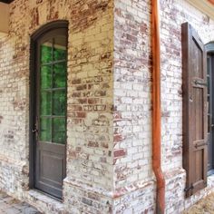 an old brick building with two doors and windows