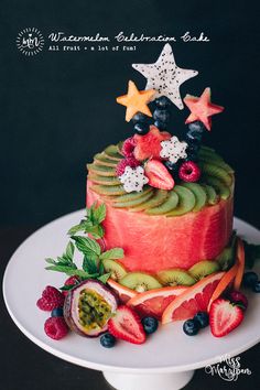 a watermelon cake decorated with fruit and stars