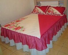 a bed with red and white bedspread on top of it