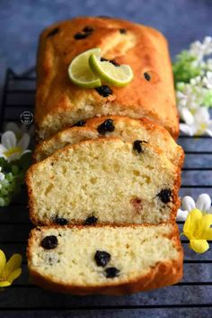 a loaf of lemon blueberry bread on a cooling rack with flowers and daisies