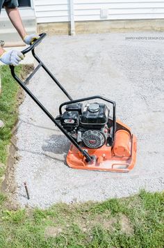 a man using a lawn mower to cut grass