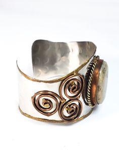 Stunning handcrafted Tri metal cuff with a large jasper center cabochon. This artisan piece has non magnetic silver plate with copper edging and twisted rope accents. There are trillion shaped swirled brass designs expertly welding into the base. Has Mexican artistic elements. These artists were known for making exceptional Brutalist style jewelry. Bracelet measures just over 2 inches thick and 7 and 1/2 inches in wearable circumference. Artistic Elements, Cuff Bracelet, Cuff Bracelets, Silver Plate, Fashion Jewelry, Copper, Cuff, Brass, Bracelet