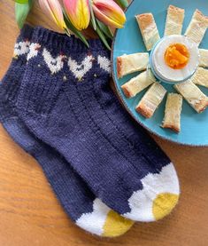 a blue plate with food on it next to some flowers and a pair of socks