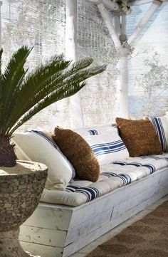 a white couch sitting next to a potted plant