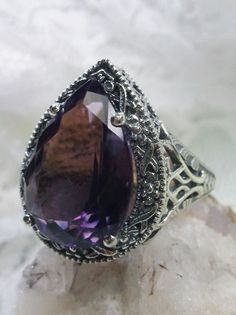 Natural Amethyst Gemstone Teardrop RingTear Vic Design#D28 Inspired by Victorian and Art Deco designs, this high-quality filigree ring is handcrafted in sterling silver. This teardrop ring is set with an 8.37 carat pear cut flawless natural purple amethyst gemstone. The gem is 16mm (~5/8") x 12mm (~1/2"). The gorgeous stones have lovely vibrant color. The inside of the band is marked 925 for sterling silver. Notice the beautiful filigree of the silver setting. This is a ring with beauty and grac Silver Amethyst Pear-shaped Jewelry, Silver Pear-shaped Amethyst Jewelry, Pear-shaped Amethyst Silver Jewelry, Elegant Teardrop Amethyst Gemstone Ring, Elegant Silver Teardrop Amethyst Ring, Elegant Teardrop Amethyst Ring, Elegant Teardrop Amethyst Ring Gift, Oval Sterling Silver Filigree Amethyst Ring, Oval Amethyst Ring With Filigree In Sterling Silver