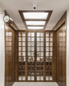 a clock is on the wall in front of an open door that leads to another room