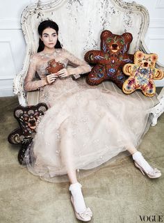 a woman sitting on top of a chair next to teddy bears