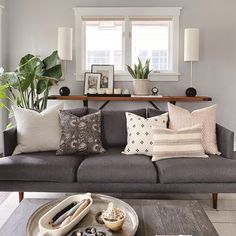 a living room filled with lots of furniture and pillows on top of a gray couch