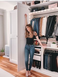 a woman standing in front of a closet full of clothes