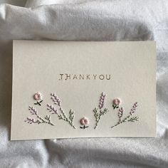 a thank you card with pink flowers on white paper and the words, thank you