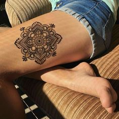 a woman's leg with a tattoo on it that has an intricate flower design