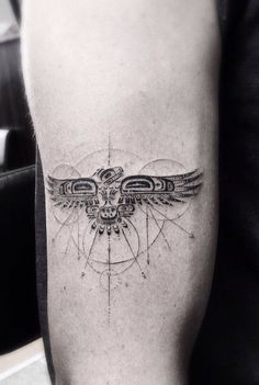 a black and white photo of a bird tattoo on the right leg, with circles around it