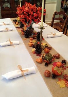 the table is set with white linens and fall decorations