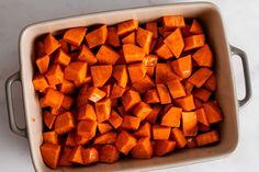 a casserole dish filled with chopped up sweet potatoes