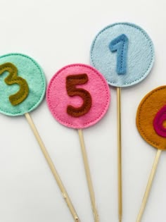 three felt numbers are on top of each other with toothpicks in the middle