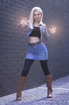 a woman in a skirt and boots posing for the camera with her arms outstretched out