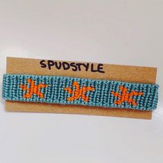 a blue and orange beaded hair clip with the words supstyle on it