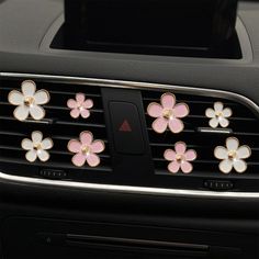 pink and white flowers are attached to the center console of a car's dashboard