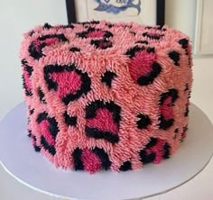 a pink and black cake sitting on top of a table