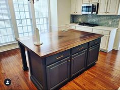 a large kitchen island in the middle of a wooden floor