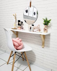 a white table topped with a mirror next to a chair