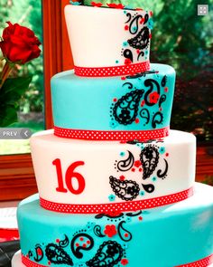 a three tiered cake decorated with red and blue designs on it's sides