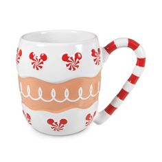 a coffee cup with candy canes on the handle and inside is decorated in red and white