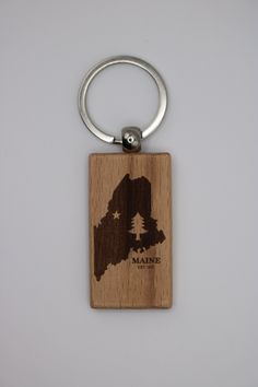 a wooden keychain with the state of maine engraved on it