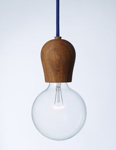 a wooden light bulb hanging from a blue cord