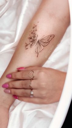 a woman's arm with a butterfly tattoo on it