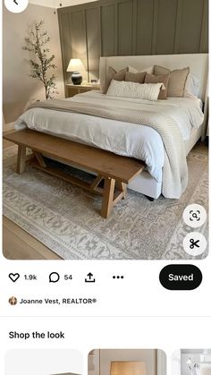 the bed is made with white linens and has a wooden foot board on it