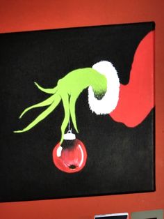 an image of a painting on the wall with red and black colors, depicting a green creature