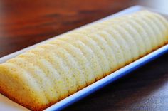 a piece of bread sitting on top of a blue and white plate next to a wooden table