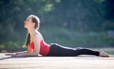 a woman is doing yoga outside on the ground with trees in the backgroud