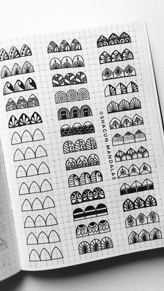 an open notebook with black and white doodles on the pages, showing different designs