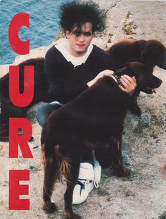 a man sitting on the ground with two dogs