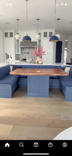 an image of a kitchen with blue couches in the center and white cabinets on the other side