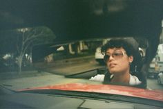 a man wearing glasses sitting in a car