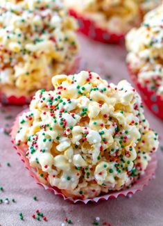 cupcakes with sprinkles and white frosting are on a table