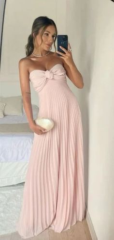 a woman in a pink dress taking a selfie