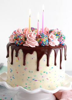 a birthday cake with chocolate icing and sprinkles on a white plate