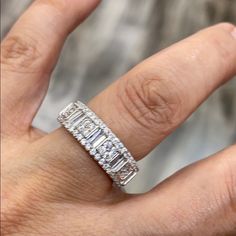 a woman's hand with a diamond ring on top of her finger and the band is set in white gold