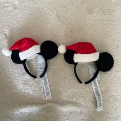 two mickey mouse ears with santa hats on them