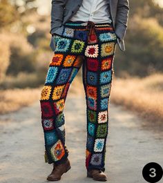 a person standing on a dirt road wearing colorful crochet pants