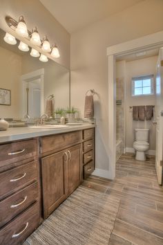 a large bathroom with wooden cabinets and tile flooring