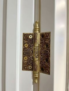 an ornate door handle on the side of a white door