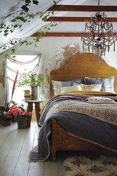 a bed room with a neatly made bed and a chandelier hanging from the ceiling