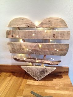 a wooden heart shaped sculpture with lights on it