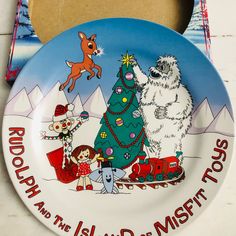 a plate that has a christmas tree and polar bear on it with the words rudolph and the island of misforts